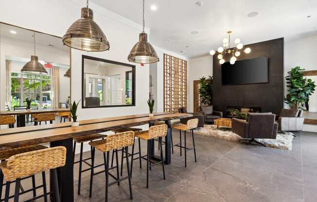 a bar area with stools and chairs and a television on the wall