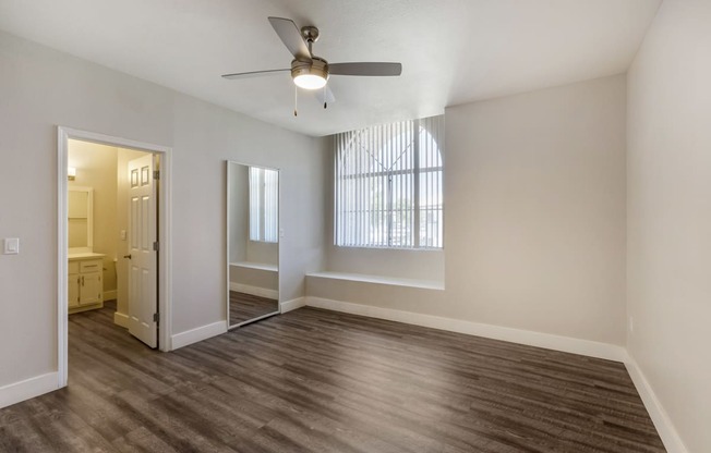 Step into our inviting bedroom, where a serene atmosphere is complemented by a soothing ceiling fan at Boulders at Lookout Mountain Apartment Homes, Arizona, 85022