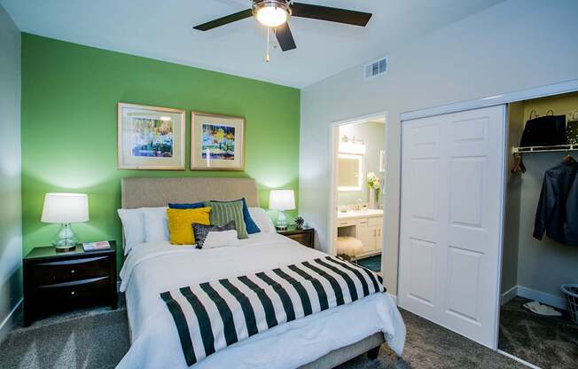 A bedroom with a bed, nightstands, and a ceiling fan.