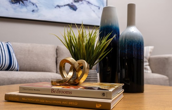 a stack of books sitting on a table with a bottle of wine
