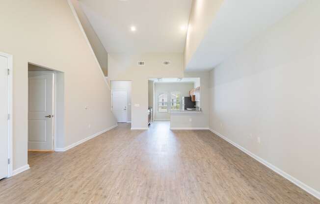 an empty living room with a hard wood floor and white walls