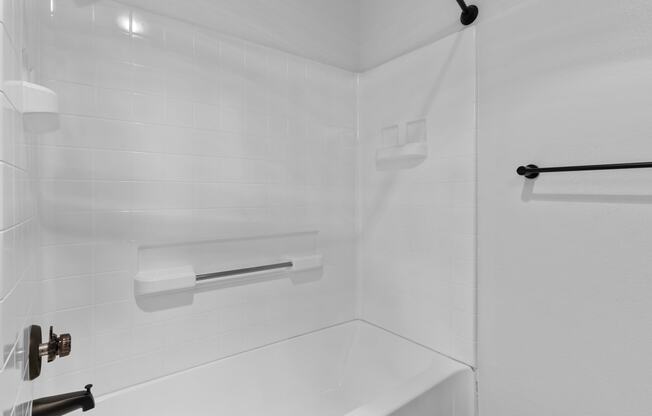 a white bathroom with a shower and a sink