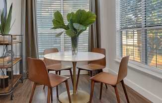 A dining room with a round table and chairs.