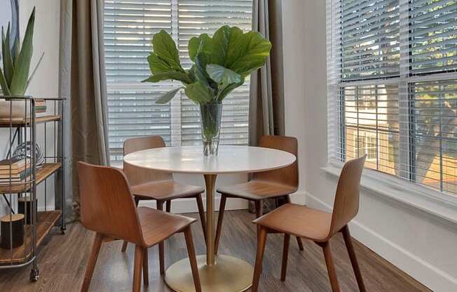 A dining room with a round table and chairs.