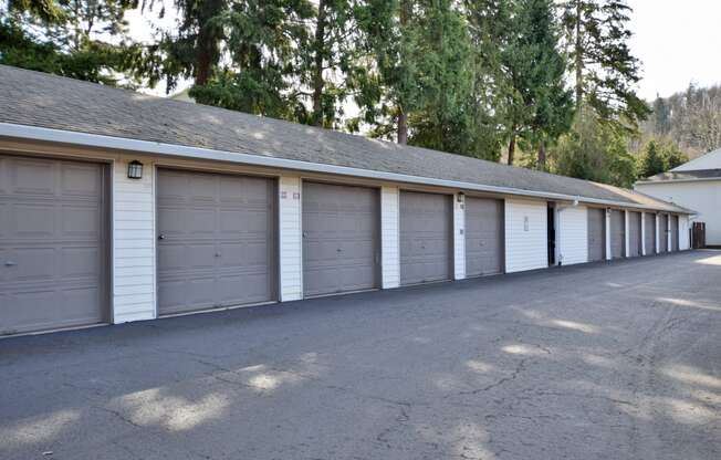 a row of three car garages in a row with trees in the background