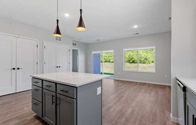 a kitchen and living room in a new home with a large island at The Lodge at Overland, Rochester, Minnesota