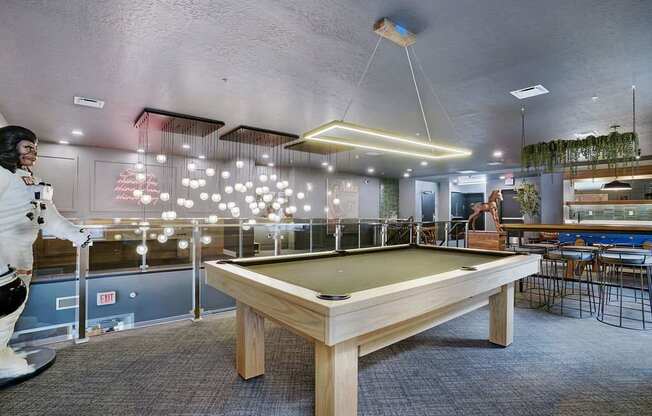 A room with a pool table and a person in a white outfit.