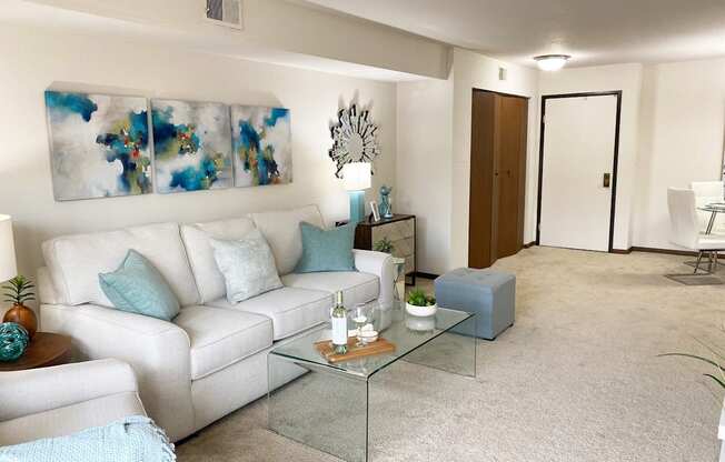 a living room with a white couch and blue pillows
