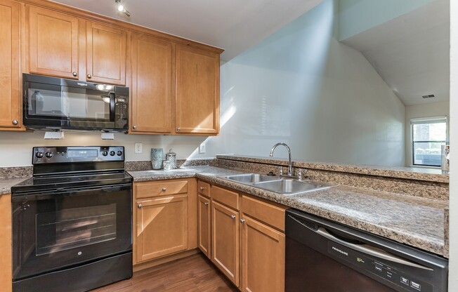 Elevate your lifestyle at Eagle Rock Apartments at Columbia. This modern kitchen features stainless steel appliances, granite countertops, and ample storage, perfect for culinary enthusiasts. Schedule a tour today to see your new home!