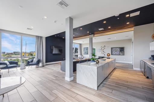 a living room with a kitchen and a large window