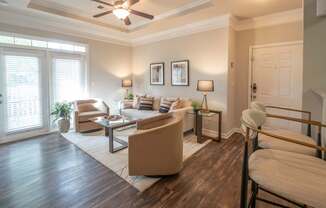 A living room with a brown sofa and a wooden floor.