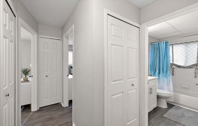 A white bathroom with a blue shower curtain.