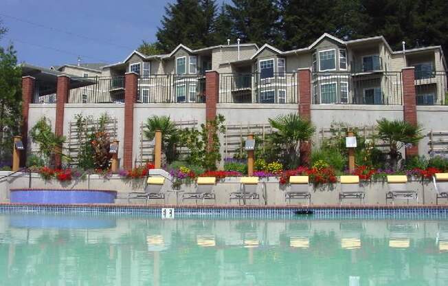 A pool in front of a building with a red brick column at Wilsonville Summit Apartments, Wilsonville , OR