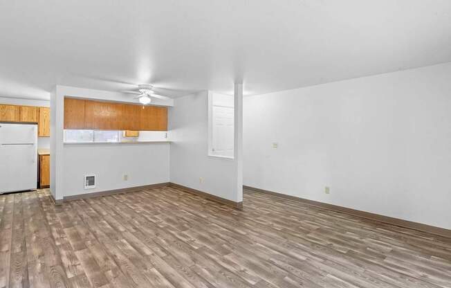 A room with wooden flooring and white walls.
