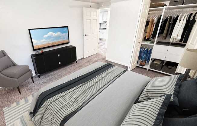 A bedroom with a bed, chair, and a television.