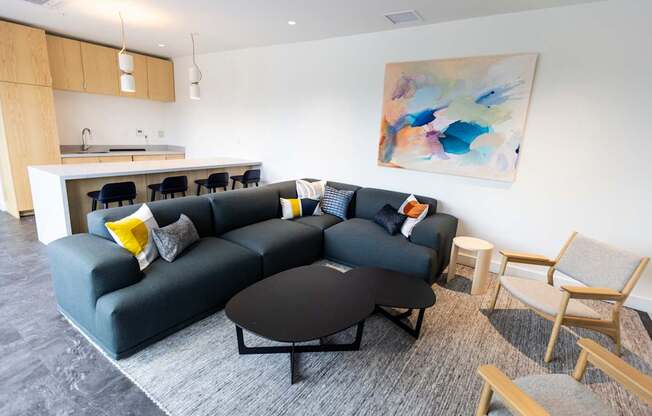 a living room with a black couch and a table and chairs
