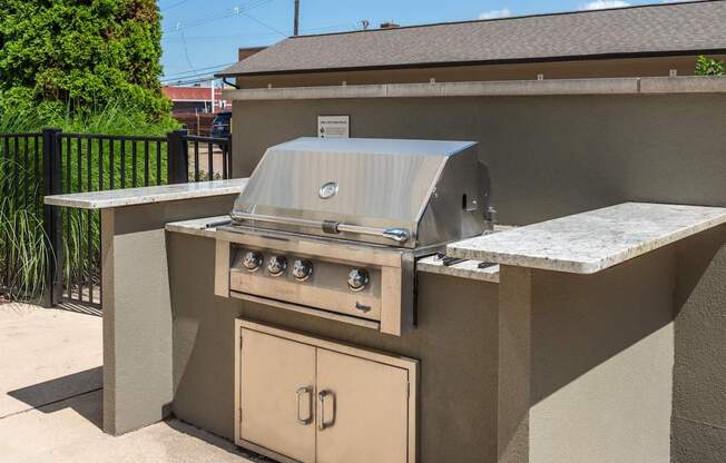 A beige outdoor kitchen with a grill and oven.