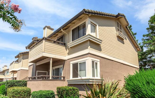 a house with bushes in front of a building