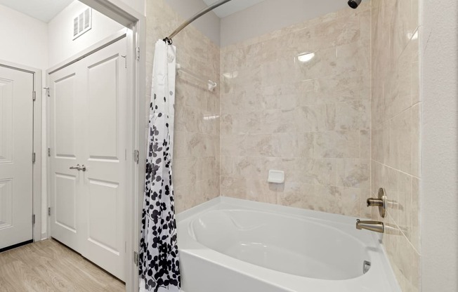 a bathroom with a tub and a shower and a door