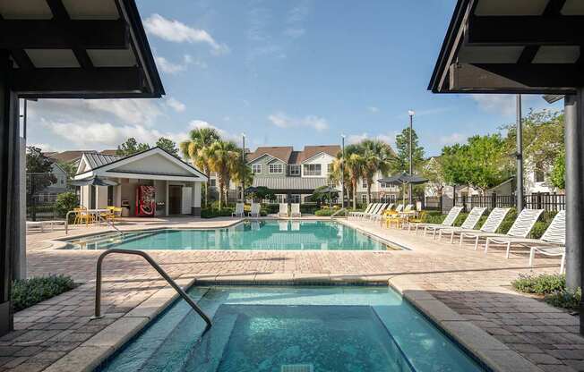 a swimming pool with white chairs around it and a house in the background