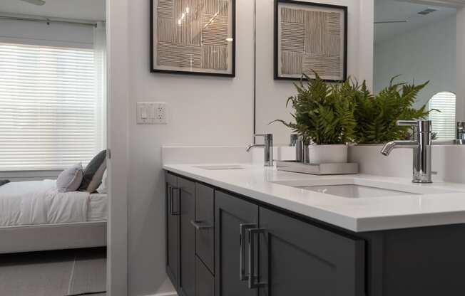 a bathroom with a sink and a mirror and a bed