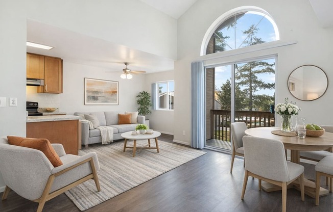 A well-lit, spacious living room with a large window and a balcony.