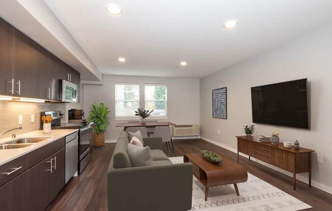 A modern living room with a grey couch and a wooden coffee table.