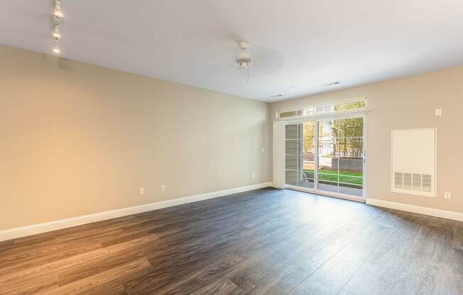 Parkside Commons vacant apartment room with wooden flooring and a ceiling fan.