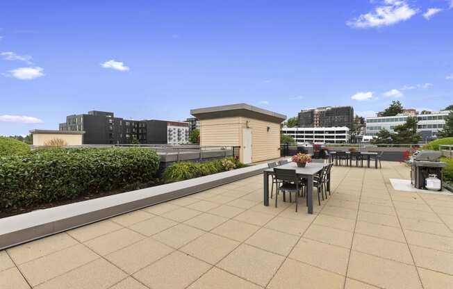 a roof top lounge space with a dining table and chairs at Villaggio Apartment Homes, Washington, 98402