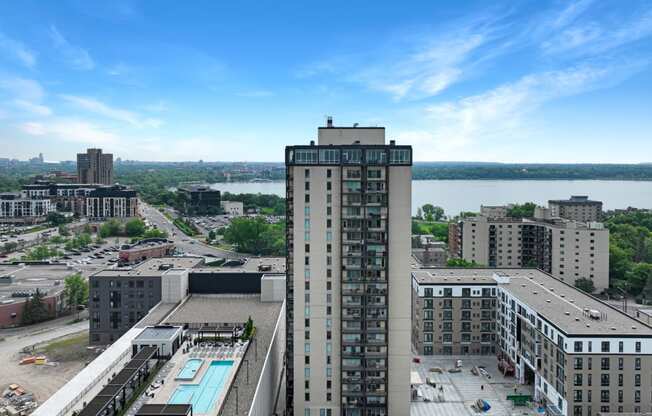 an aerial view of a tall building with a pool in front of it