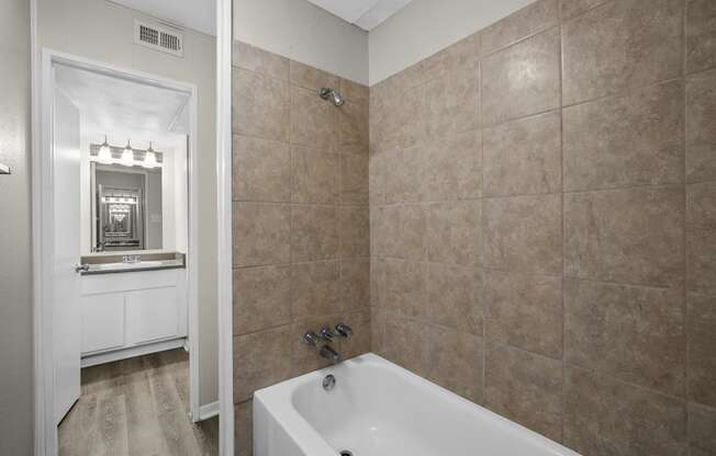 a bathroom with a tub and a sink and a mirror at Brookside Apartments, Texas, 76643