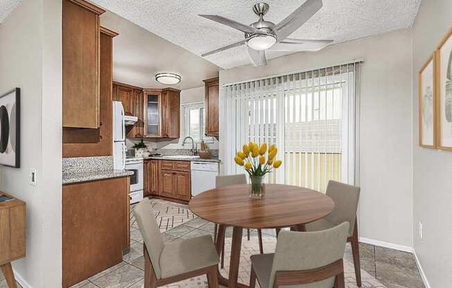 Apartment dining area with a table and four chairs looking out to the private patio. The kitchen is off to the left at Pacific Sands, California, 92117