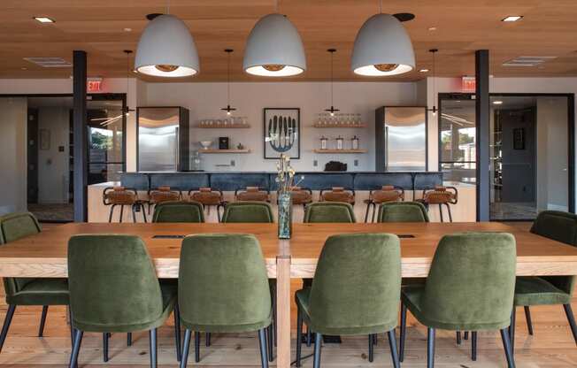 a communal table in a restaurant with green chairs