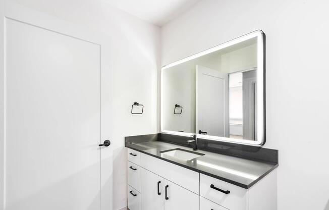 Bathroom vanity with a clean-lined sink, integrated lighting, and streamlined cabinetry creating a bright, functional space for daily routines.