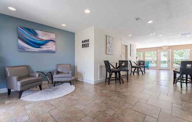 A living room with a blue wall and a painting on it.