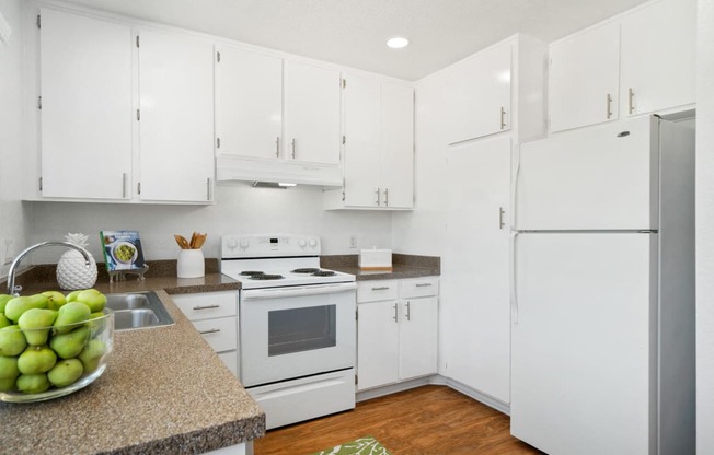 a white kitchen with white appliances and white cabinets