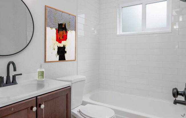 a bathroom with a toilet and a tub and a sink