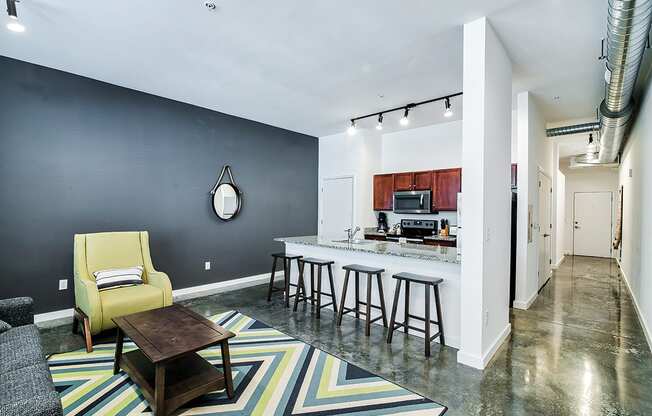 living room with a kitchen in the background and a yellow chair in the foreground