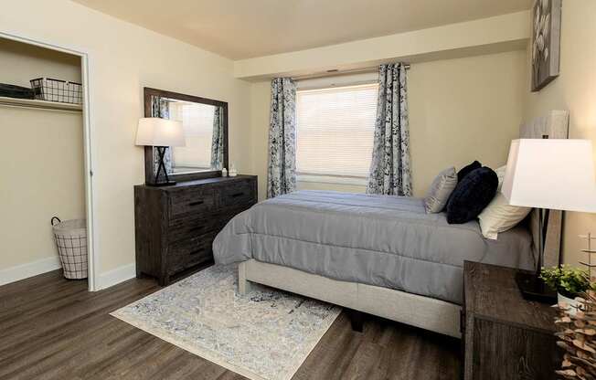 A second bedroom with a bed, nightstand, and a rug.