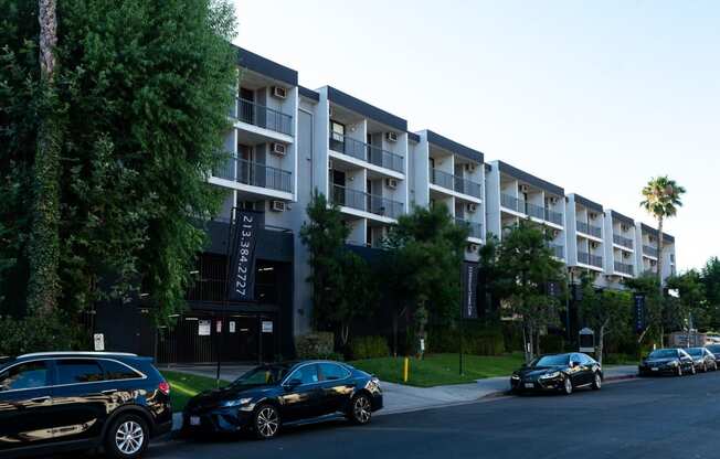 an apartment building with cars parked in front of it