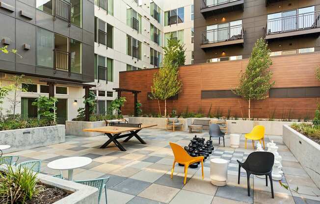 A patio with a table and chairs is surrounded by buildings.