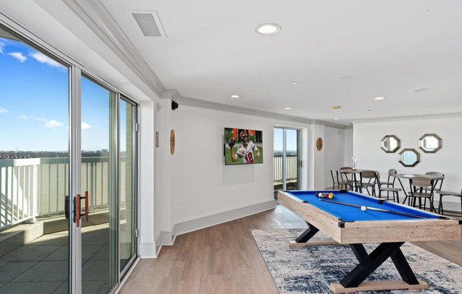 a living room with a pool table and a balcony