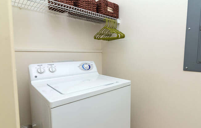 A white washing machine sits in a laundry room.
