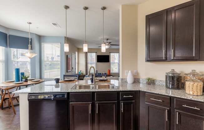 a kitchen with dark cabinets and a counter top with a sink