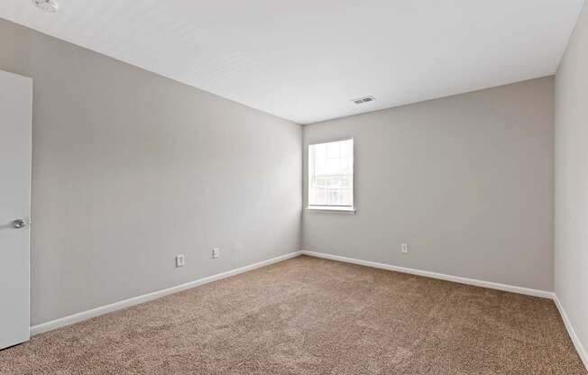 an empty room with carpet and a window