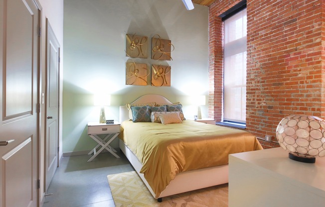Exposed Brick from the Original Building Enhances the Bedroom