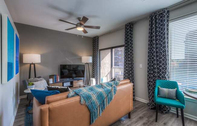 a living room with gray walls and a ceiling fan