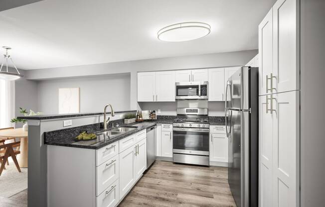 a kitchen with white cabinets and stainless steel appliances