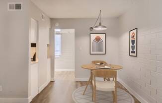 a dining area with a round table and two chairs