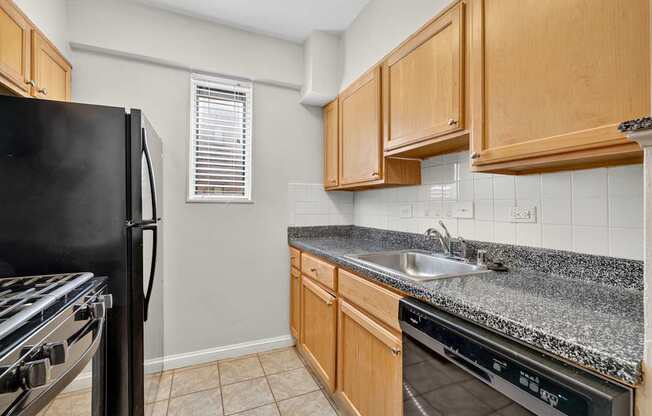 A kitchen with a black fridge, stove, and oven.